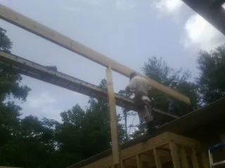 Carpenter setting a ridge beam over a new addition frame — Ice Dam Removal by Roofing Brothers in Vernon Hills