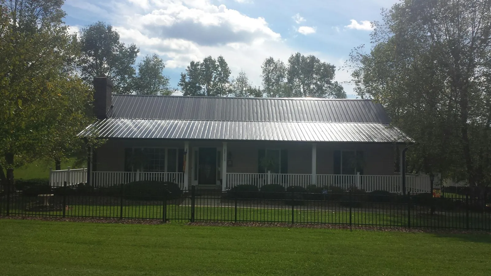 Gray metal roof on a brick ranch with a full width front porch — Gutter Guard Installation work by our crew in Vernon Hills