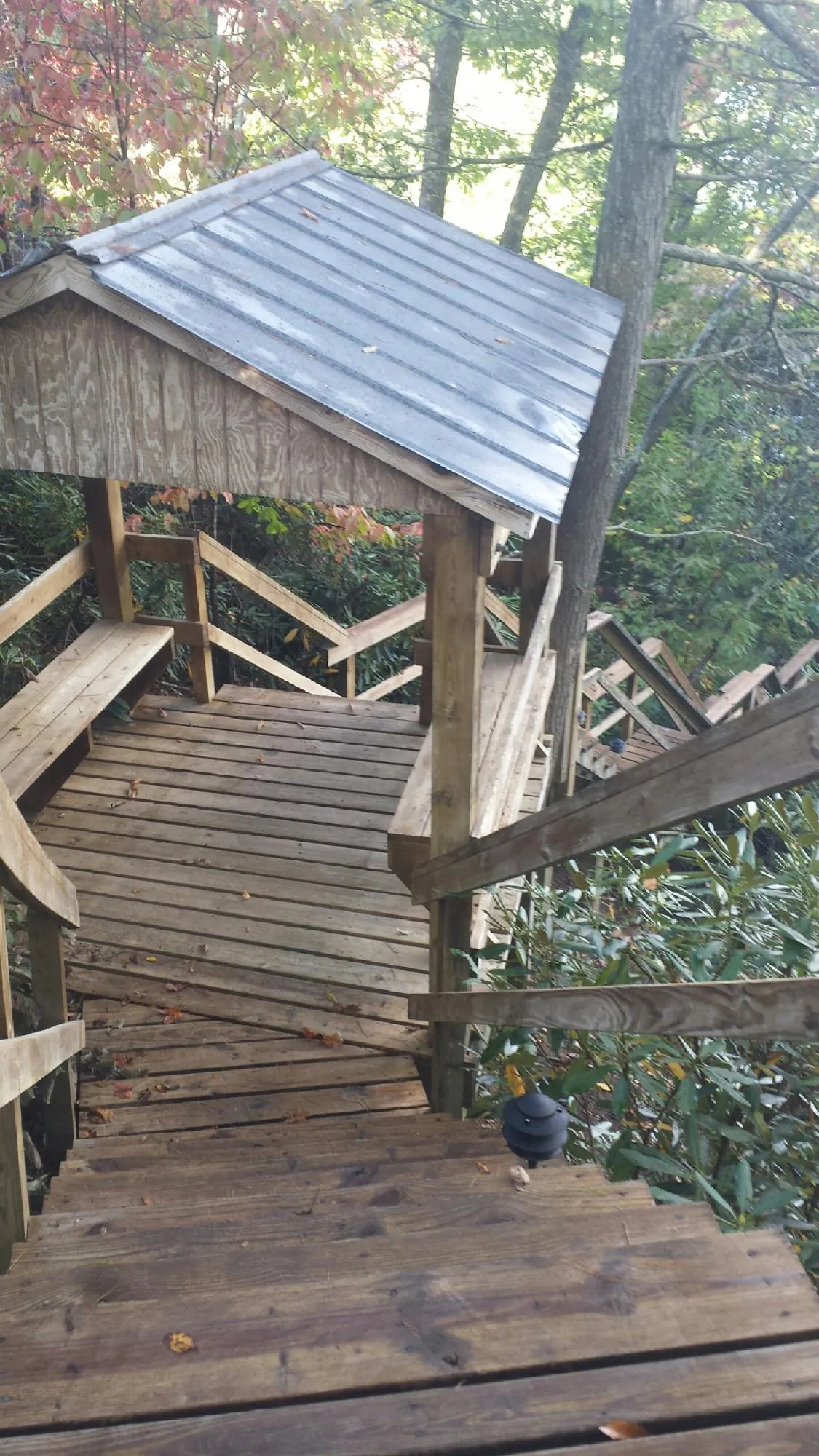 Metal roofed shelter over wooden steps on a wooded walkway — Skylight Repair & Installation work by our crew in Vernon Hills