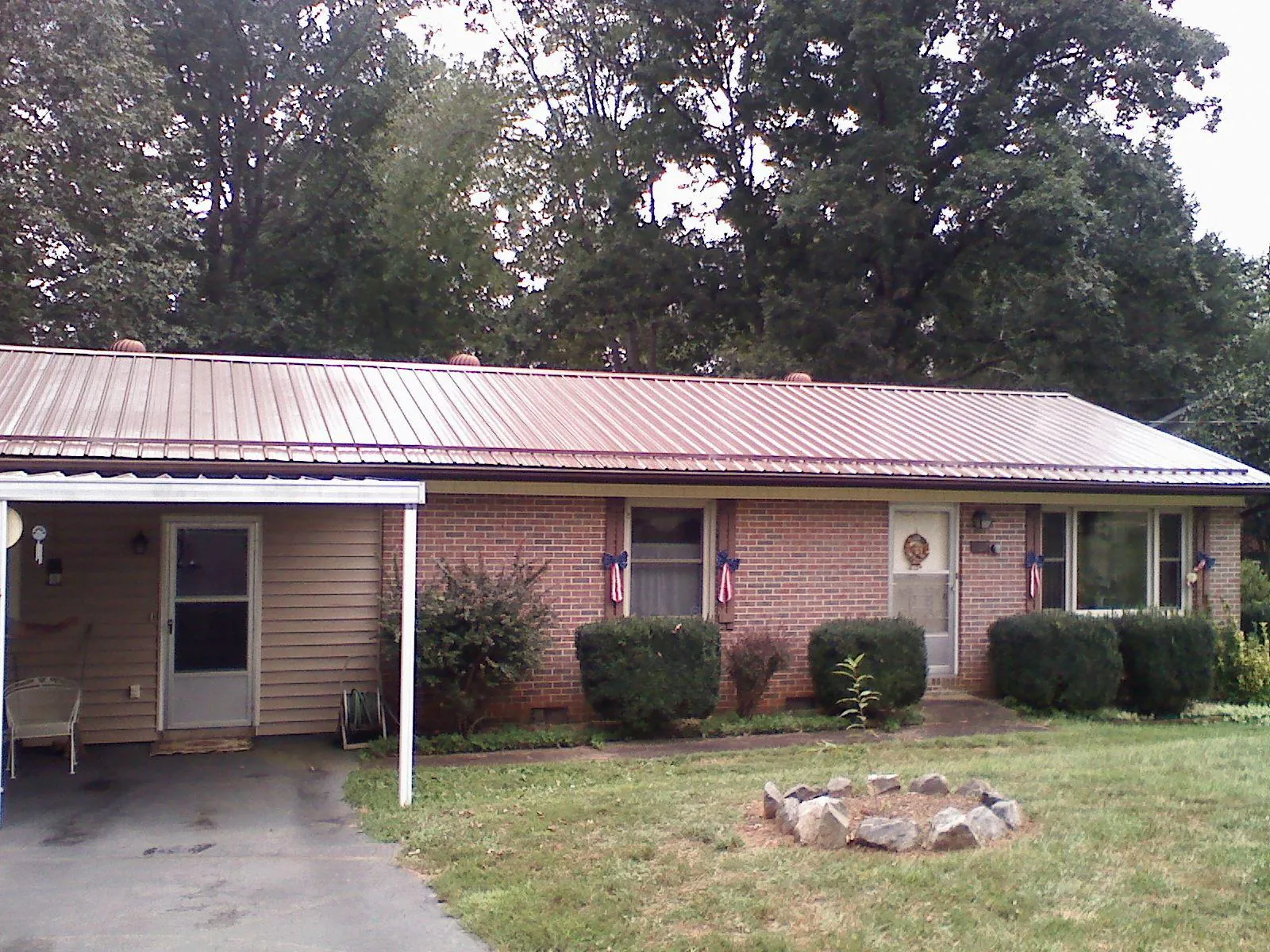 Bronze metal roof and carport on a brick ranch home — Roof Repair work by our crew in Vernon Hills